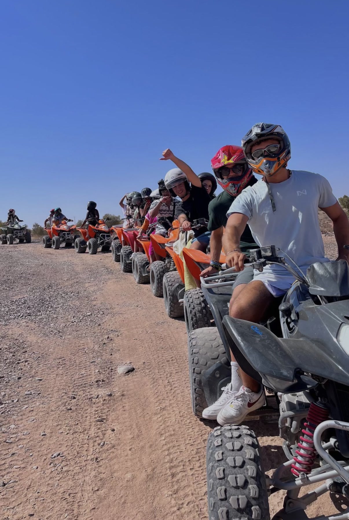 Grupo alinhado em moto quatro, com capacetes