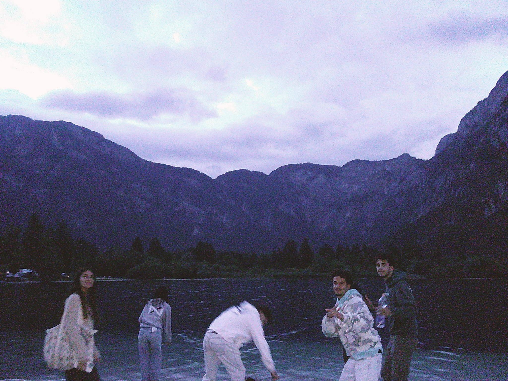 Amigos junto a um lago de montanha ao anoitecer