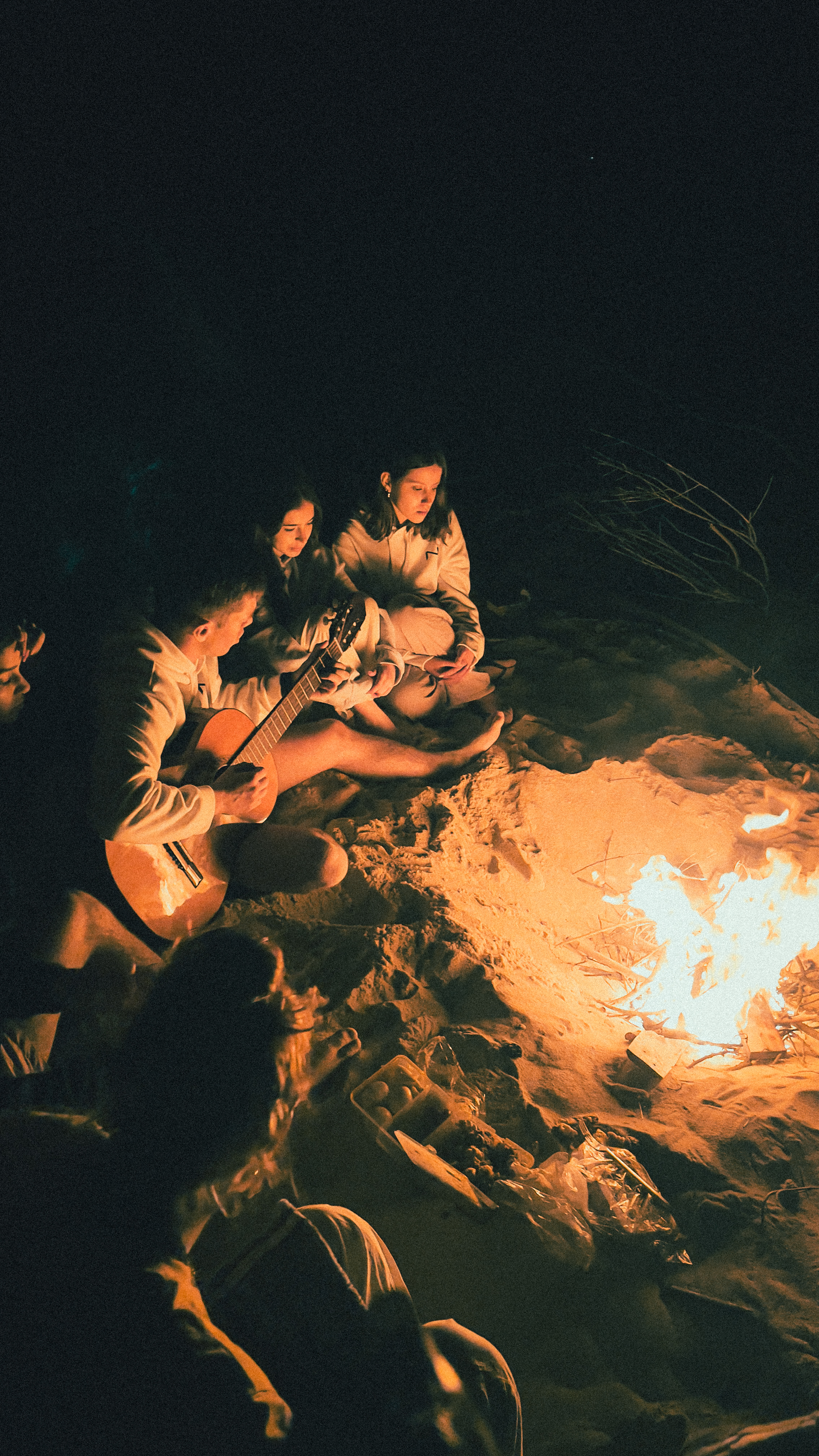 Amigos à volta de uma fogueira ao anoitecer
